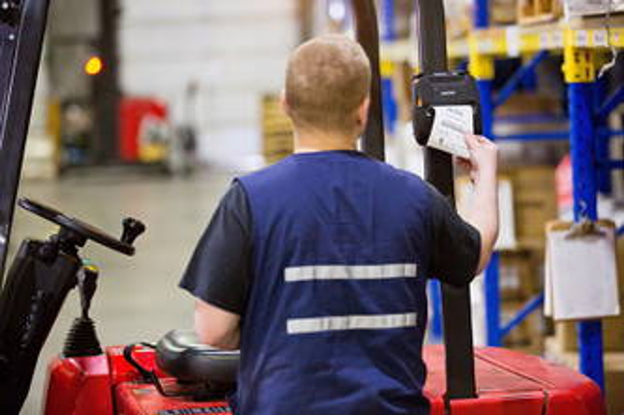 a warehouse worker using a portable label maker to print labels